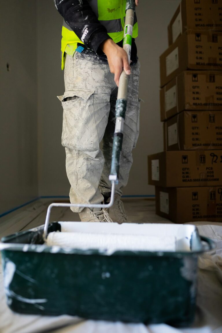 Person using a putty knife to fill holes on an interior wall before painting.