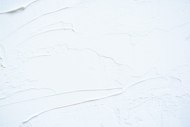 Paint samples beside a wall showing flat, eggshell, and satin finishes under natural light.